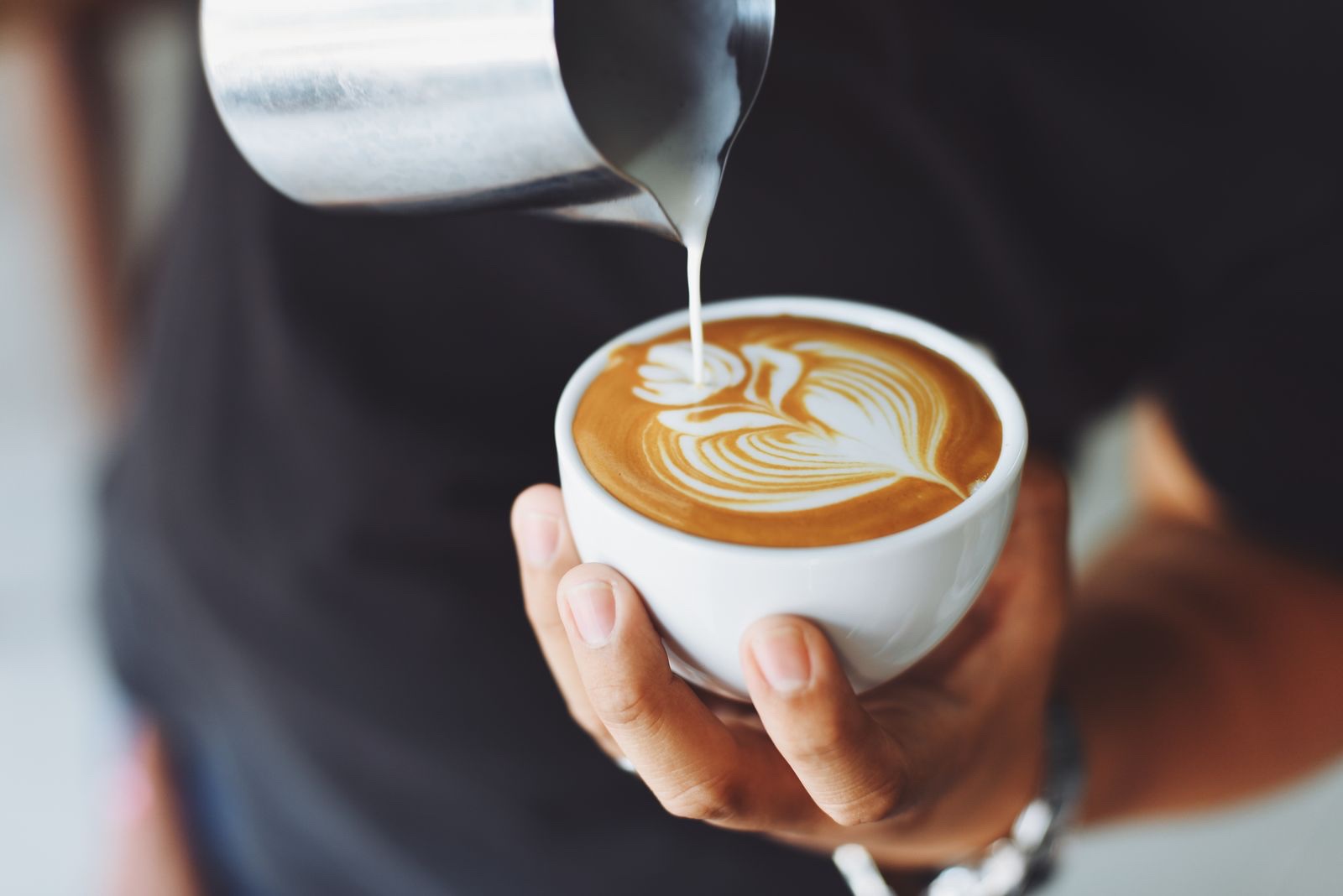 A barista pouring a latte